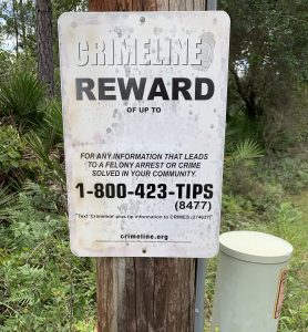 Sign tacked to tree reads crimeline reward of up to...fot any information that leads to a felony arrest or crime solved in your community. 18004238477. Text ‘crimeline’ plus tip information tocrimes (274637). Crimeline.org